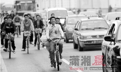  新颖而又低碳的自行车迎亲一路上吸引了不上过往车辆的注意。本组图片/记者王伟