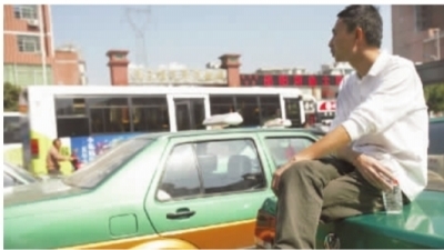 10月17日，长沙平安出租车有限公司门口，姜的哥坐在车上无奈地说：“公司一直没有给车办牌照，导致无法上路经营。”记者 武席同 摄