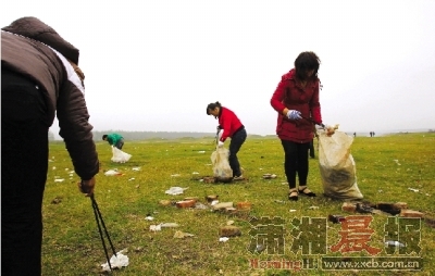  11月7日下午，长沙月亮岛，附近居民和志愿者清理游客留下的垃圾。 图/记者刘有志