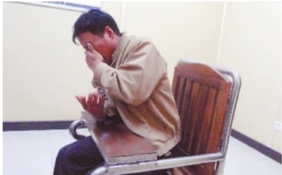  11月26日晚，逃亡16年的陈再根被长沙警方捉拿归案，在长沙市开福区公安分局四方坪派出所审讯室内，提到独自在家的70岁老父，陈再根哭着说“对不起”。 记者 王智芳 摄 