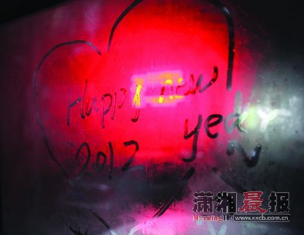 昨日，株洲市府路，一位市民在起霜的车窗上写“Happy　new　year，2012”。图/记者陈杰