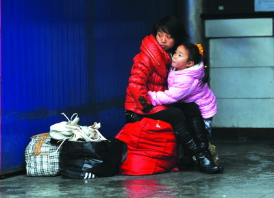 1月3日，一位女士带着小孩在候车。图/记者周健