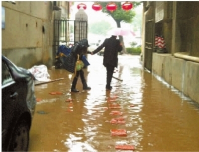 因为楼道里堵满了水，长沙市宝安综合楼的住户们每天都要“过河”。