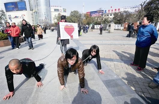 女子一人牵三男宣示“女权”，市民评价不一 记者邹斌 摄 