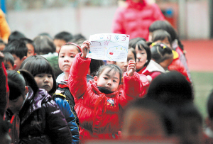 　昨日上午，曙光路小学开学典礼上，一名小女孩举起了向雷锋学习的手抄报。 邱晓峰 摄 