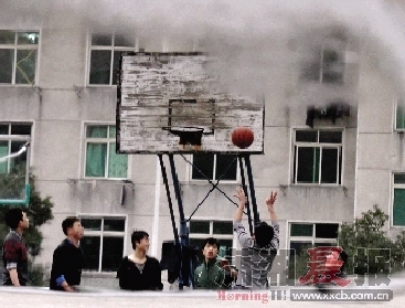 昨日，长沙铁道学院篮球场的积水投影出场上的身影。图/记者刘有志