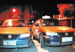 两辆真假难辨的出租车在中南汽车世界“狭路相逢”。左边的是套牌车。　　小刘军 摄
