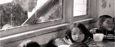 3月31日，贵州织金县八步镇中心小学，学生的家长站在教室窗外看小孩吃午餐。图/记者辜鹏博