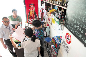 市食安办工作人员对桐梓坡路附近的小餐馆食品安全进行检查。 邱晓峰 摄 