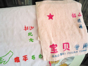 　　谭述修在展示他发明的带有识别标志的毛巾产品。刘炬 摄