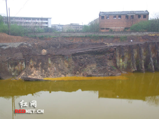 铬污染土壤旁边的深挖池中的水呈现出金黄色。
