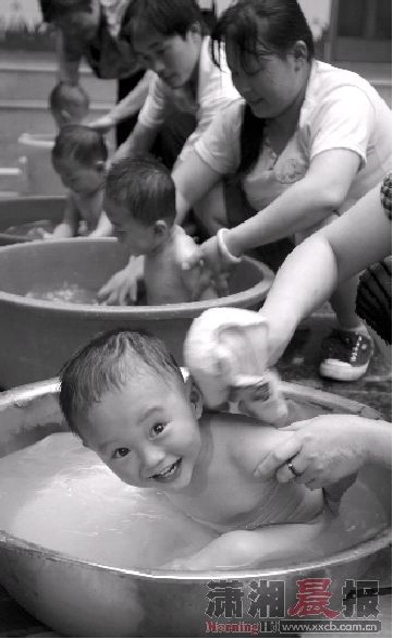  四胞胎一起洗澡，盆不够用水桶上。图/记者殷建军