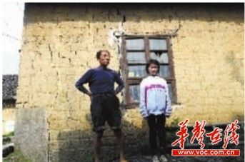 4月24日，小春梅和爷爷站在即将倒塌的住房前。