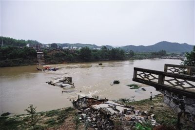 5月13日，垮塌桥体的残骸散落在河中。当日8时50分许，由于连续暴雨，致使湖南省平江县梅仙镇与余坪乡交界附近一座大桥突然发生垮塌。新华社记者 白禹 摄