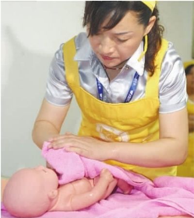 接受培训的准月嫂正在细心照顾一名“新生儿”。