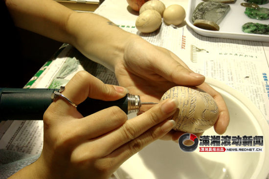 5月25日上午，在湖南省展览馆内，来自广东的左蓉羽独家表演了鸡蛋壳上刻字、作画的技术。图/潇湘晨报滚动新闻记者 陈斌