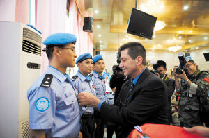 　联合国驻利比里亚特派团官员为中国维和警察授勋。胡红章 供图