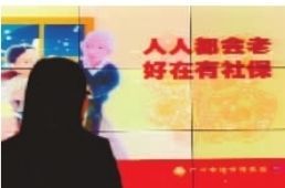 一广州市民在观看社会养老保险的宣传画。