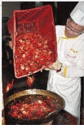 6月29日，中国湘菜大师杨军在厨房精心烹饪口味虾。 实习生 唐俊 摄