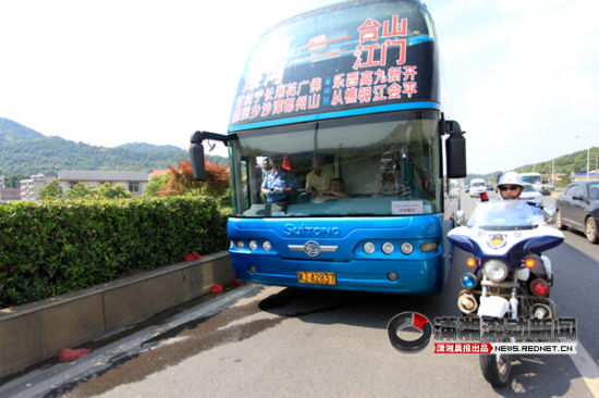 　(7月4日，一辆牌照为湘J42837的大客车，因超载被网友微博举报后，在长沙二环线王家湾路段被长沙交警查获。 图/潇湘晨报通讯员 许晓)