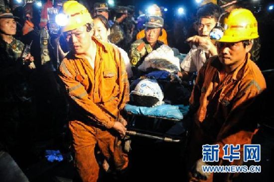  7月8日，首名获救的矿工刘运青被救援队员用担架抬出。新华社记者 白禹摄