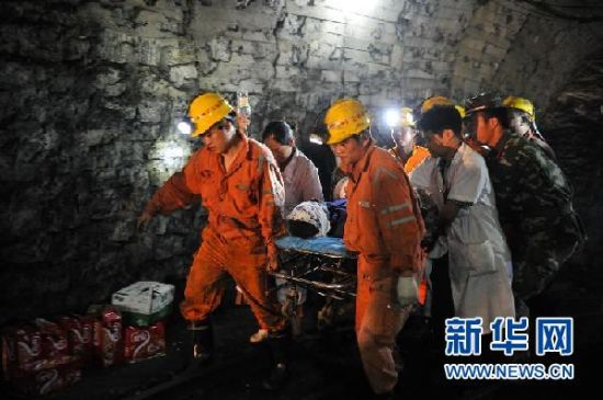 7月8日，首名获救的矿工刘运青被救援队员用担架抬出。新华社记者 白禹摄