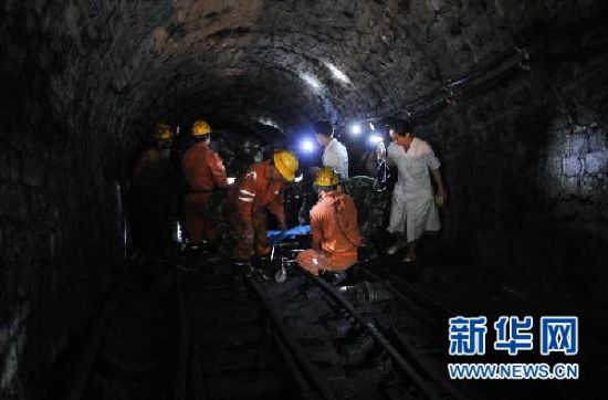 7月8日，首名获救的矿工刘运青被救援队员用担架抬出巷道。新华社记者 白禹摄