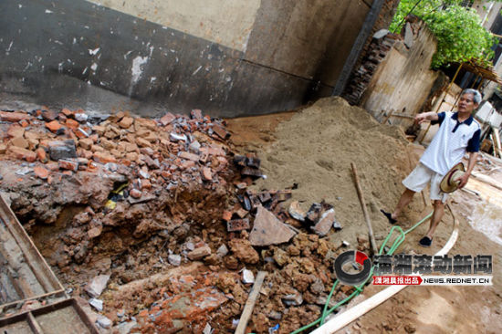 (7月12日，曙光北路的人民新村45栋的空地被挖了一个坑，居民们担心影响地基。 图/潇湘晨报滚动新闻记者 范思鼎)