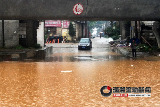 (7月16日，长沙暴雨。黎托乡轻轨高架桥下积水很深阻隔了道路，上午有车辆在这里抛锚。)