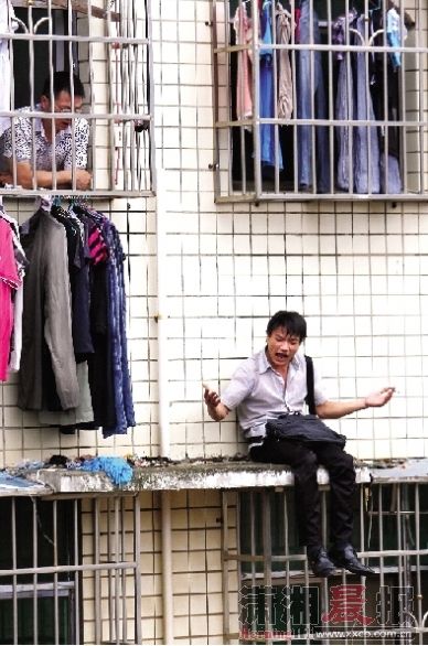 昨日下午，芙蓉区高岭小区，一名男子坐窗台上，情绪激动地喊叫要跳楼。 图/记者刘有志 