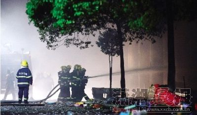 7月18日零时许，星沙凉塘路口处的聚鑫大厦突发火灾，十余辆消防车赶到现场灭火。至凌晨3点55分，大火被扑灭。图/记者陈勇 