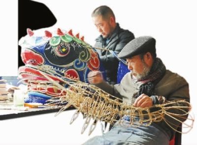 国家级凤凰纸扎传承人聂方俊带儿子做龙虾骨架.武吉海 摄