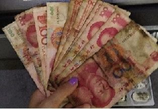 　　8月27日，长沙市民李薇(化名)去ATM机取到了一叠“黑钱”，看上去像被火烧过。 图/李薇微博图片