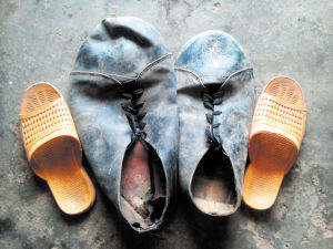 陈合明破旧的皮鞋里能放下三只拖鞋。均为朱炎皇 谷桔 摄影报道