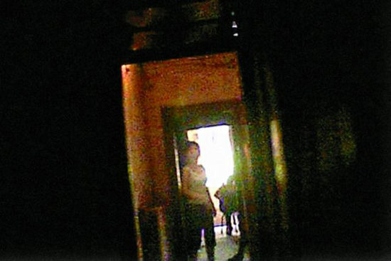 图为性工作者站在房门前等客。