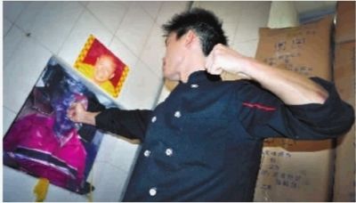 10月25日，长沙市黑石铺某餐馆，一名员工在发泄室里向老板的照片挥拳。 实习生 李健 摄