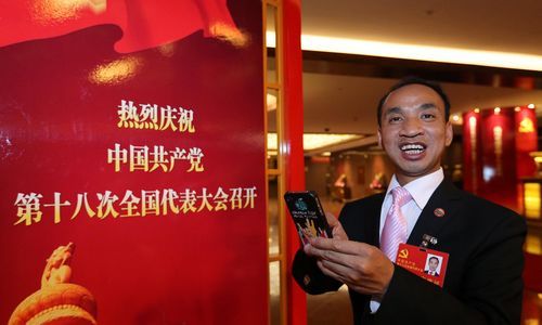 马恭志代表通过手机微博将家乡的变化带到北京，也将党的十八大盛况及时传递给粉丝。本报记者 张目 摄