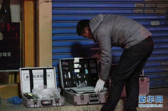11月16日，在湖南娄底娄星区长青中街，刑警在遭到抢劫的金器店勘察。新华社发（郭国权摄）