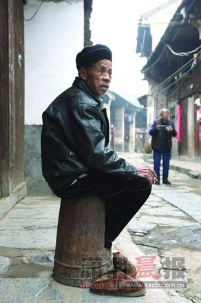 11月13日上午，新宁白沙镇白沙老街，86岁的唐生应吃过早饭，坐在火桶上跟街坊聊天。 