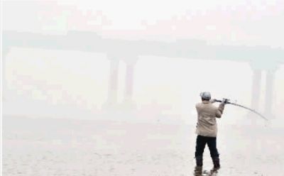 1月15日，湘江长沙段，一位市民在雾霾笼罩中钓鱼。记者 范远志 摄