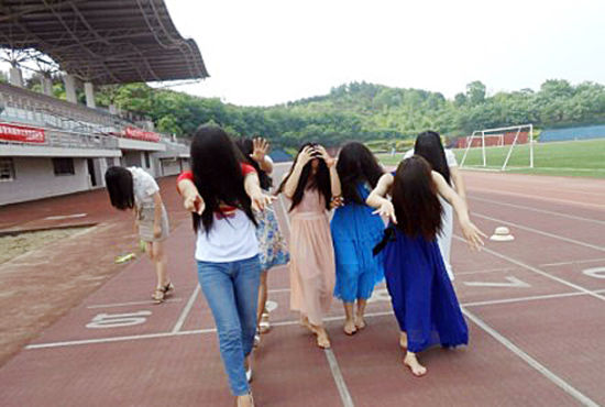 (长沙理工大学工商管理2009级的7名女生，想拍点特别的毕业照，于是在学校田径场摆出各种“灵异”的姿势。)