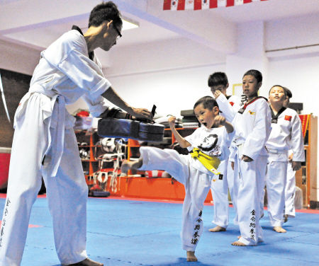 正在贺龙体育中心跆拳道馆进行训练的孩子们。邹麟 摄