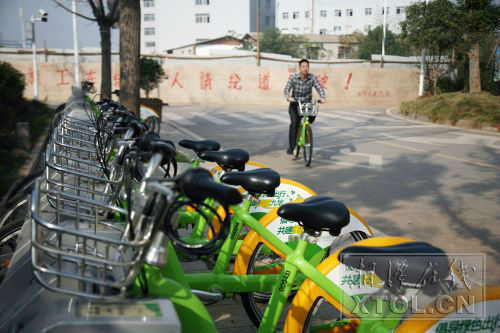 湘潭经开区自行车租赁点旁，一市民在骑公共自行车。(记者 罗韬 摄)
