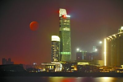 10月8日18时55分，一轮红色月亮在长沙市城区上空升起(多次曝光)。 本报记者 童迪 摄