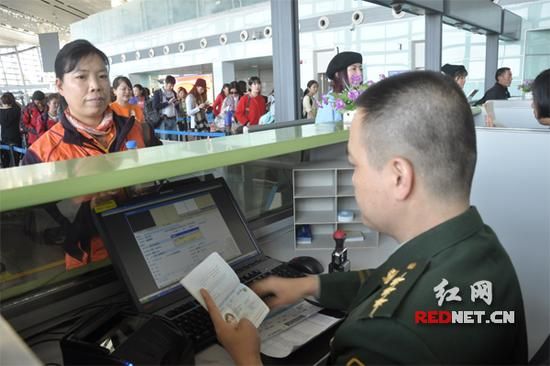 长沙边检站工作人员正在细致查验出境人员证件信息。