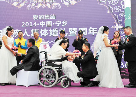 昨日上午，宁乡首届残疾人集体婚礼举行，7对新人穿上崭新的礼服、洁白的婚纱，与大家分享幸福和甜蜜。王志伟 摄