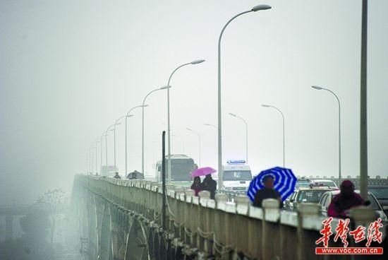 1月13日， 雾霾笼罩下的长沙橘子洲大桥。当天，雾霾造成城区空气质量下降、能见度低。 记者 郭立亮 摄